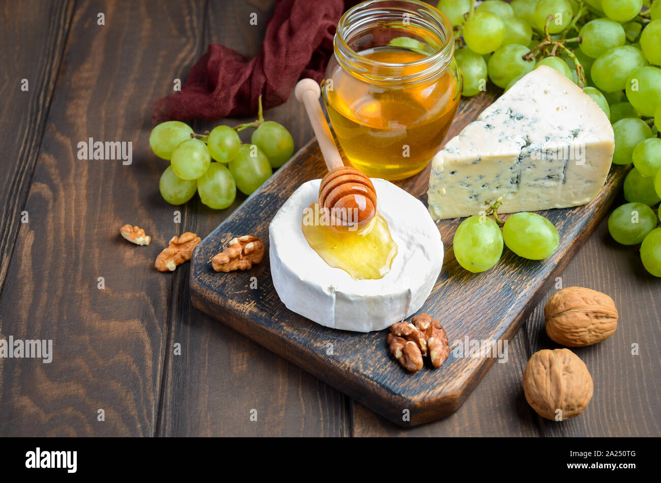Varietà di formaggio con l'uva, le noci e il miele. Foto Stock