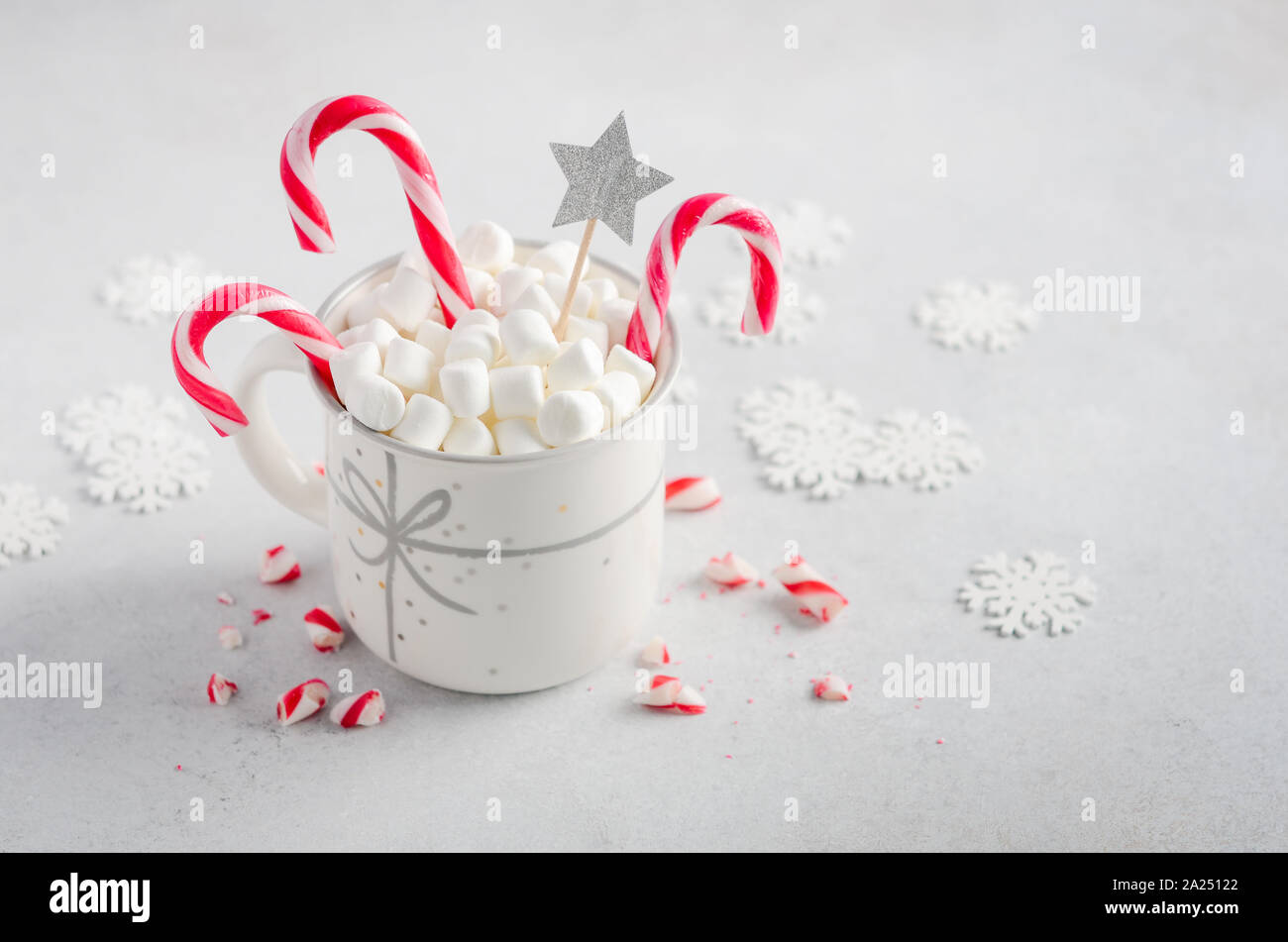 Anno nuovo o il concetto di Natale. Composizione con marshmallows e candy canes su un cemento grigio Sfondo. Foto Stock