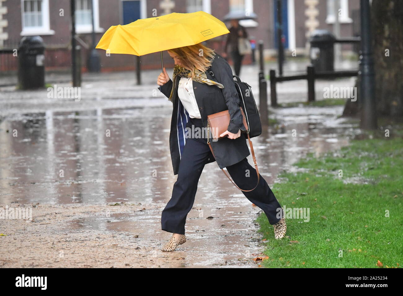 Un pedone schivato il pozzanghere mentre si ripara dalla pioggia sotto un  ombrello in Queen Square, Bristol, dopo il Met Office ha avvertito di  piogge torrenziali e tuoni in alcune parti del