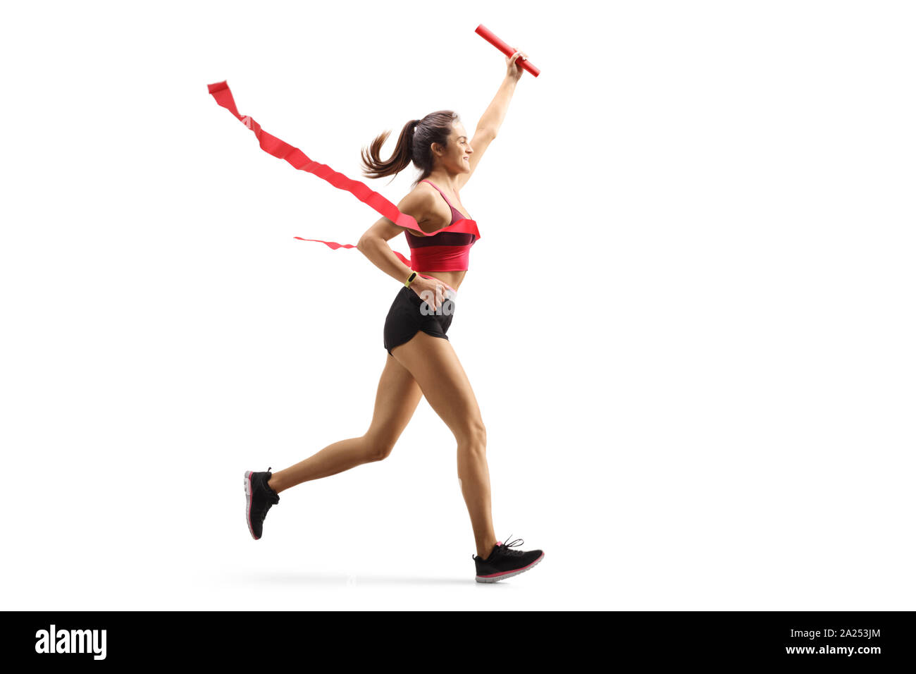 Lunghezza piena ripresa di profilo di una femmina di runner sulla linea del traguardo di una staffetta con un bastone nella sua mano isolati su sfondo bianco Foto Stock