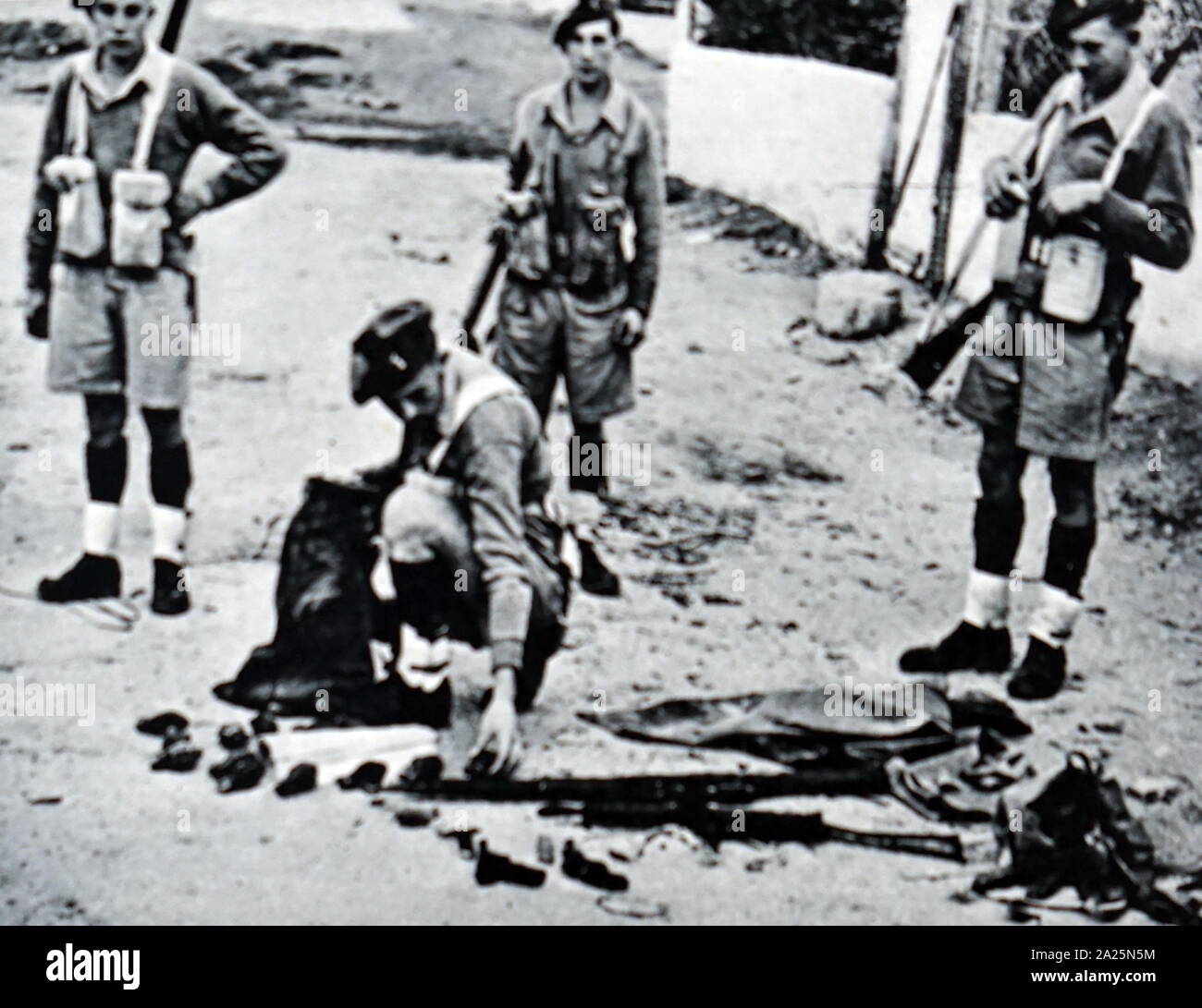 Fotografia di truppe britanniche di smistamento di armi scoperte in una cache su Tel Aviv - Jaffa frontiera. Foto Stock