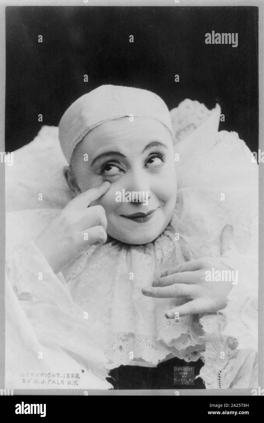 Pilar Morin come clown/mime: testa e spalle, rivolta leggermente a destra; mano alzata a occhio destro Foto Stock