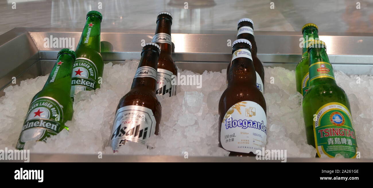 Europei e Cinesi di bottiglie di birra, il raffreddamento in un letto di ghiaccio, ristorante di Pechino, Cina Foto Stock