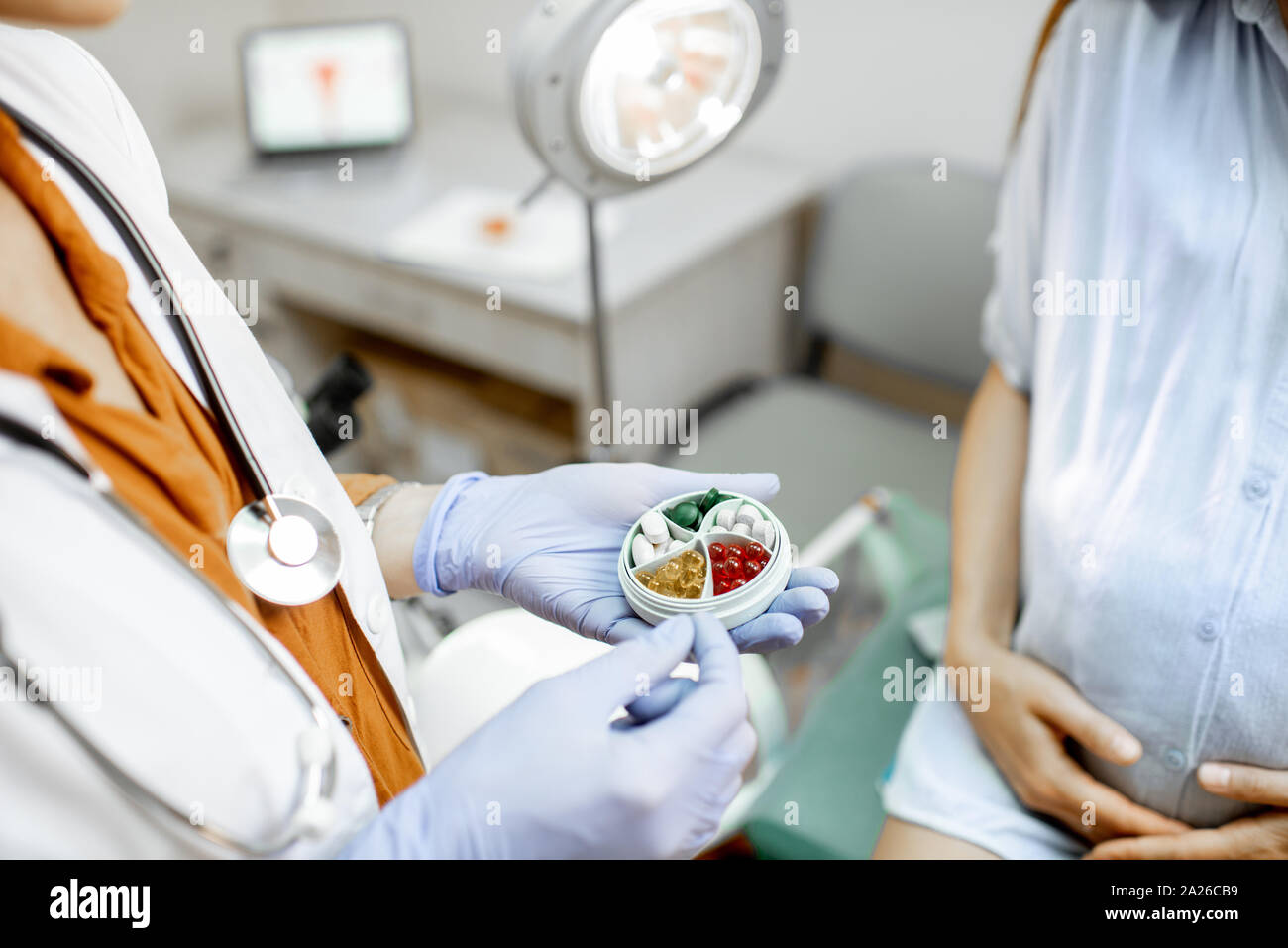 Medico azienda scatola di pillole con qualche medicina in ufficio ginecologiche, vista da vicino sulle mani e le pillole Foto Stock