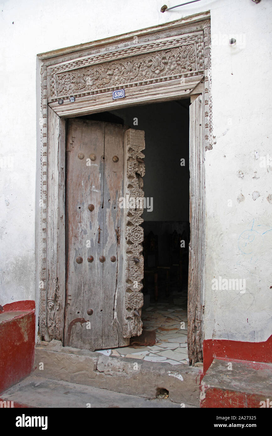 Erosi vecchio stile Arabo arte porta scolpito, Stone Town, Zanzibar, isola di Unguja, Tanzania. Foto Stock