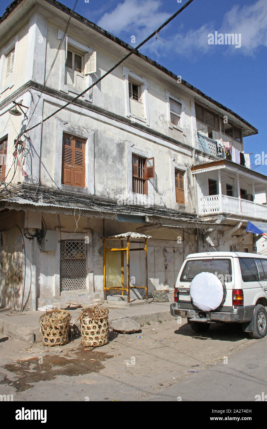 Usurati apartment building block e Pajero jeep 4x4, Stone Town, Zanzibar, isola di Unguja, Tanzania. Foto Stock