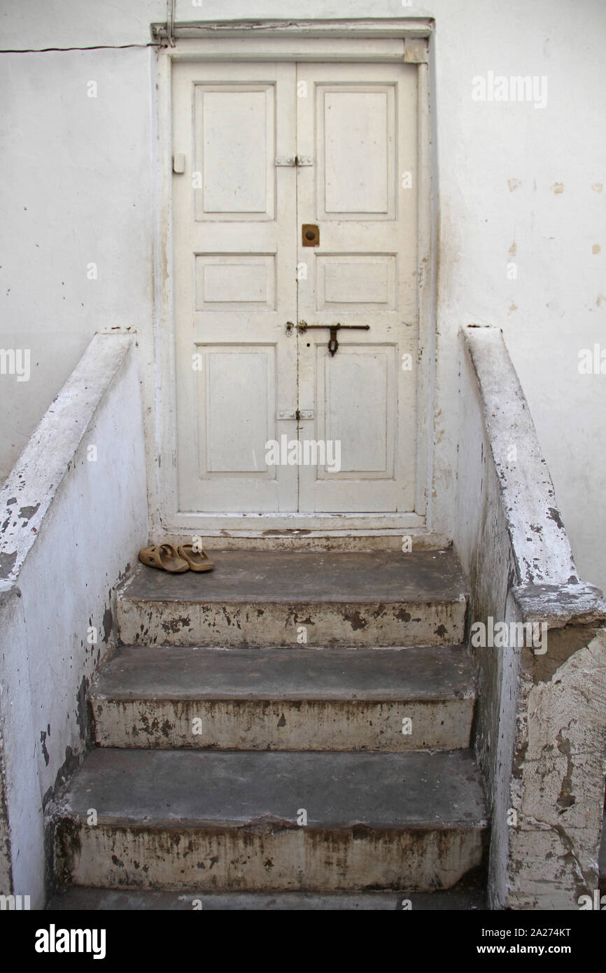 Scala di colore bianco e pareti che conducono a un bianco vecchia porta di legno, frpont porta di una casa di paese in pietra, Zanzibar, Ungujs Isola, Tanzania. Foto Stock