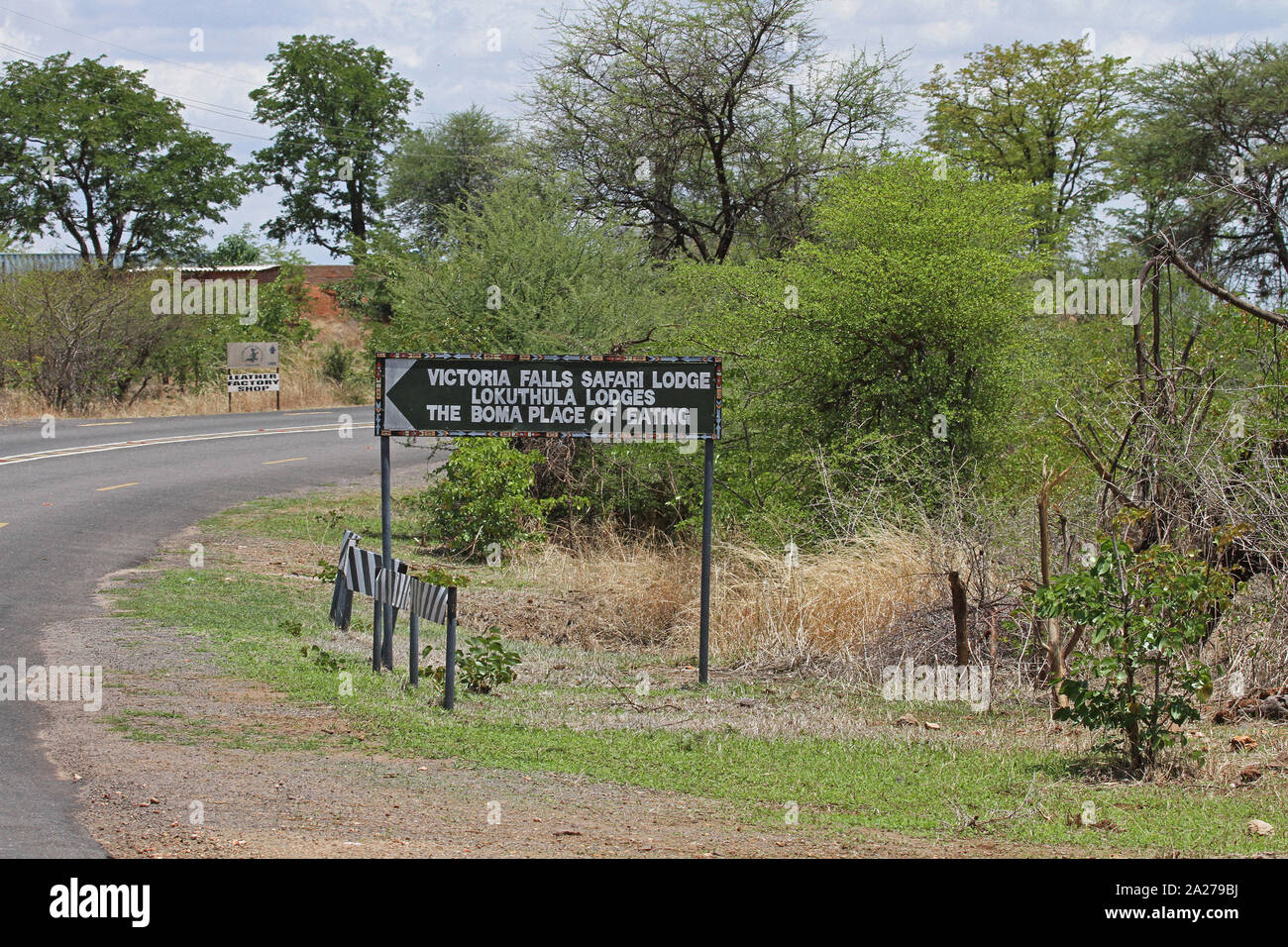 Segno rivolto alla più vicina lodges, zone pranzo e la fabbrica di cuoio shop on road, Victoria Falls National Park, Zimbabwe. Foto Stock
