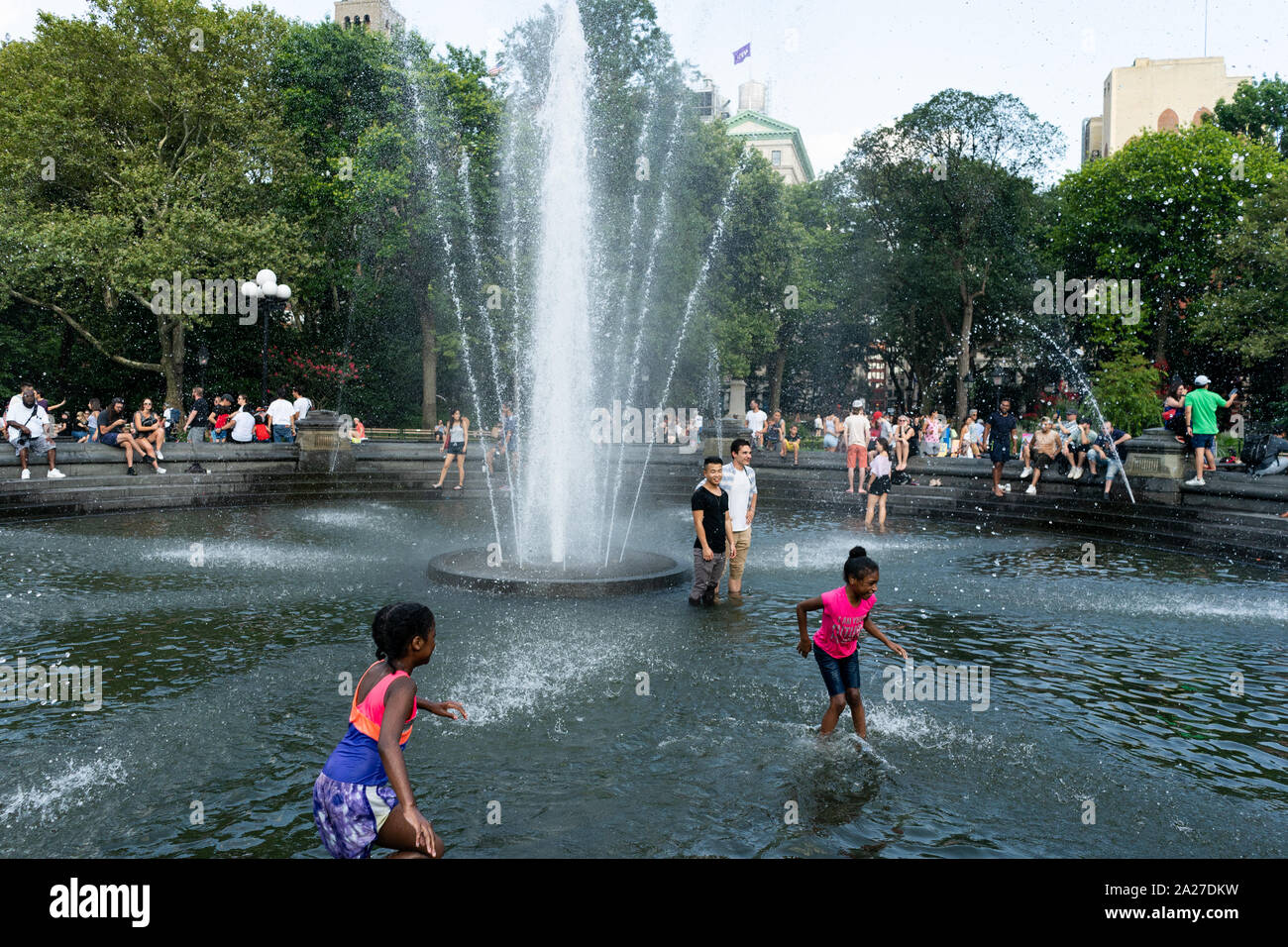 Persone raffreddare in Washington Square Fontana al Washington Square Park di New York City il 28 luglio 2019. Foto Stock