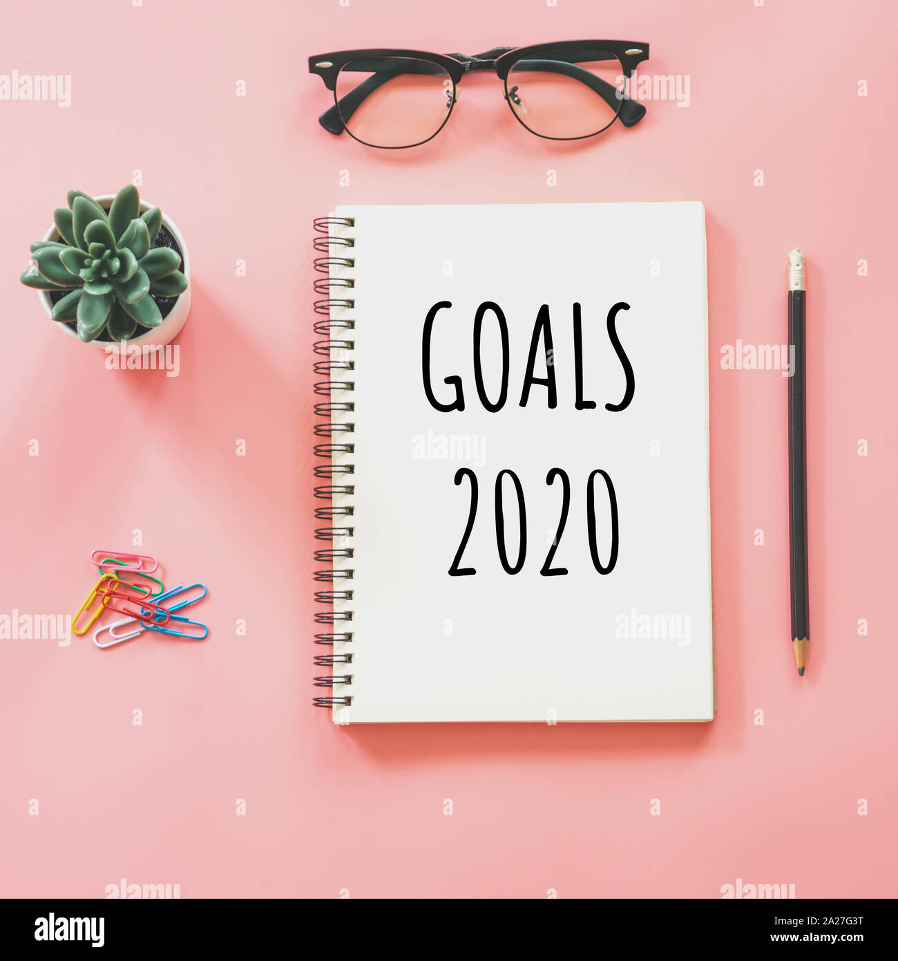 Anno nuovo concetto. Obiettivi 2020 e blocco note, smartphone, cancelleria a pink color pastello con spazio di copia Foto Stock