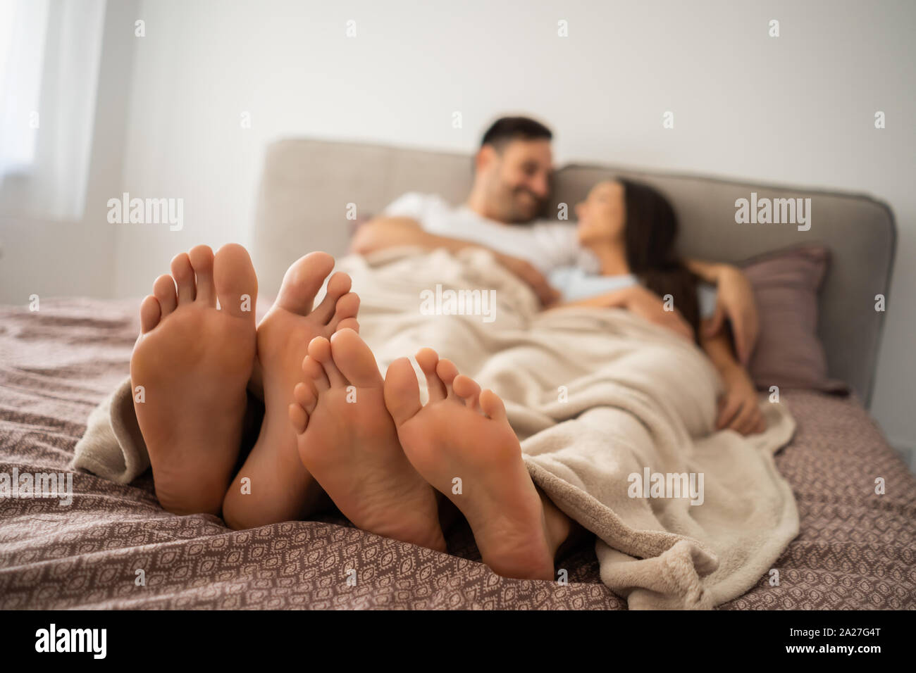 Coppia felice è divertente e rilassante se stessi a letto. Foto Stock