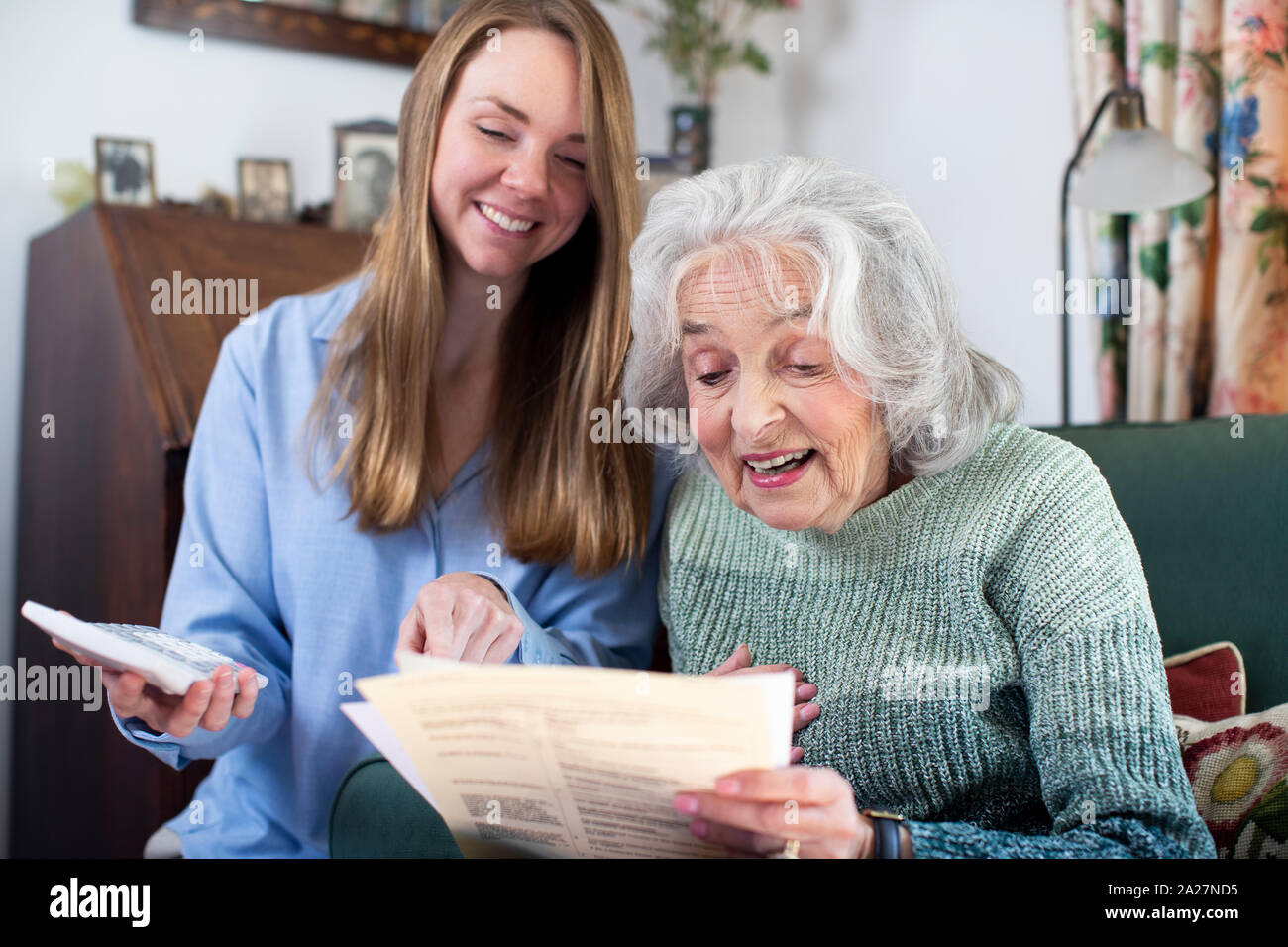 Donna aiutando Senior il prossimo con fatture e documenti Foto Stock