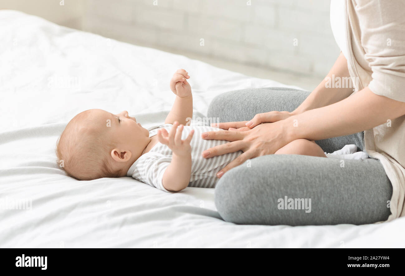 Donna massaggiare la pancia del suo figlio prevenire coliche renali Foto Stock