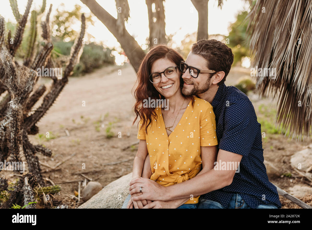 Metà adulto giovane abbracciando sulla roccia di sorridere quando essi abbraccio vicino Foto Stock