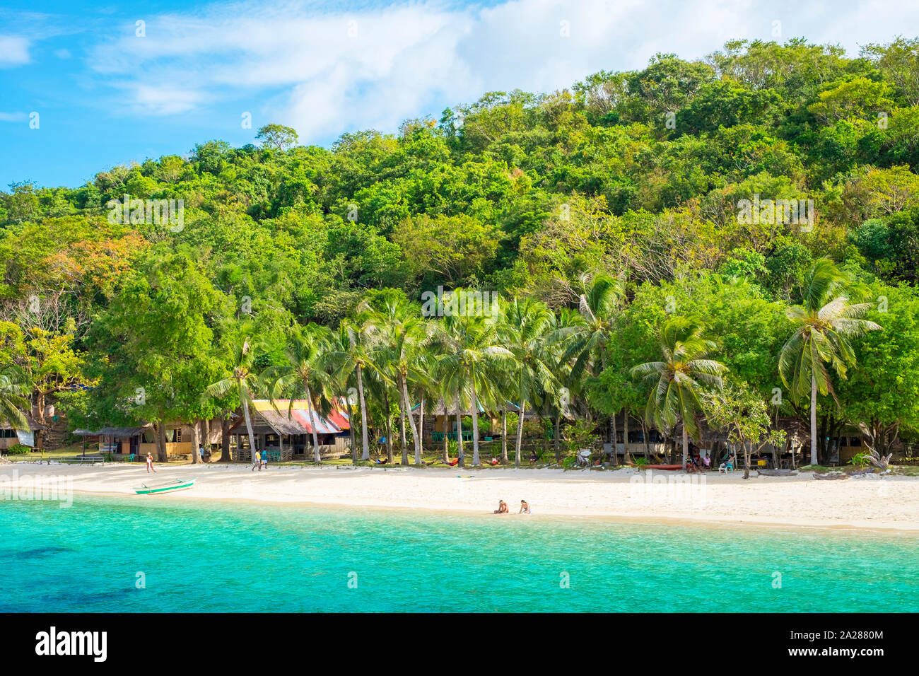 Due persone sedute sulla spiaggia di sabbia bianca a Banana Island, Coron, PALAWAN FILIPPINE Foto Stock