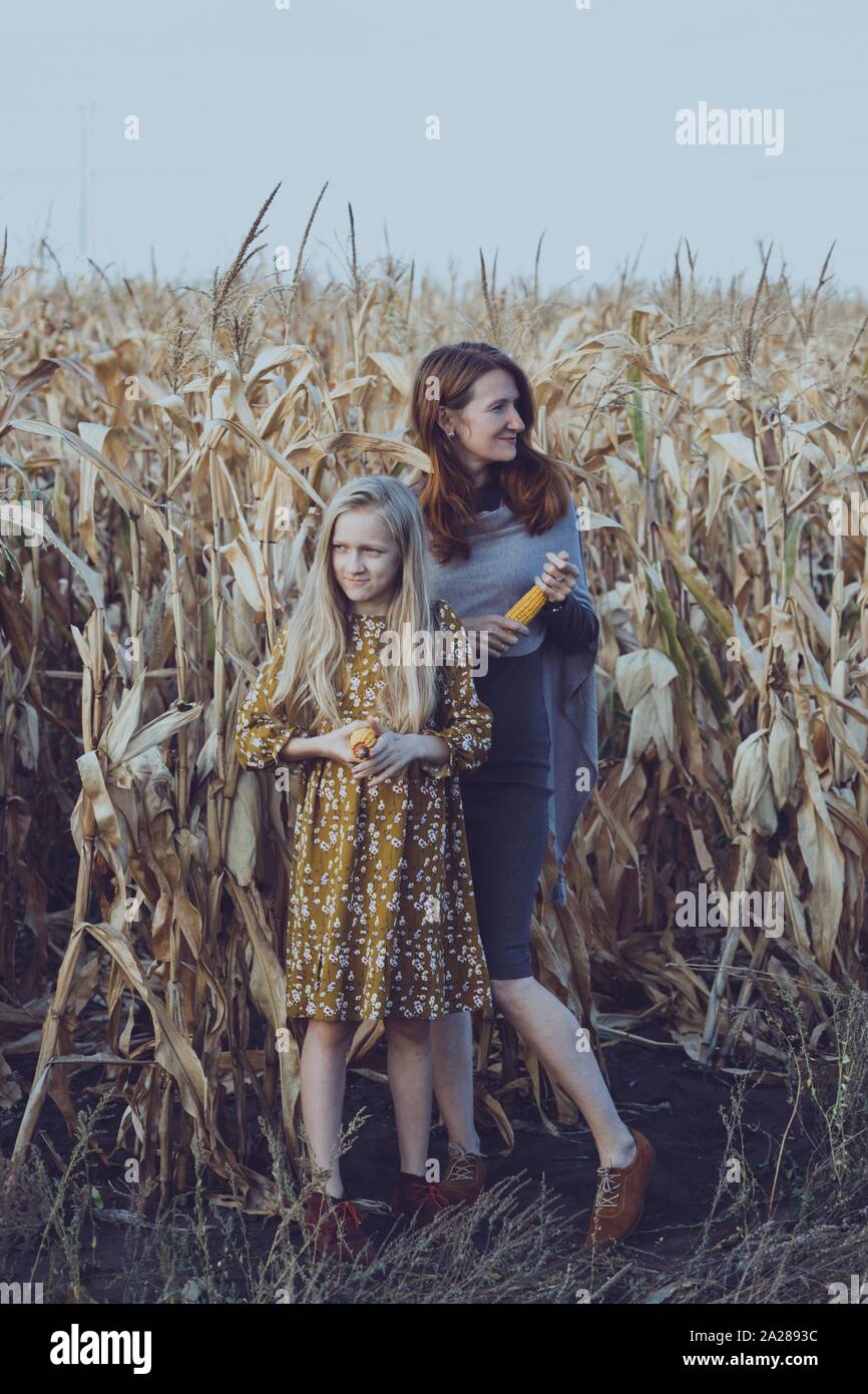 La famiglia e la vita al di fuori della città. mamma e figlia in un campo di mais. Foto Stock