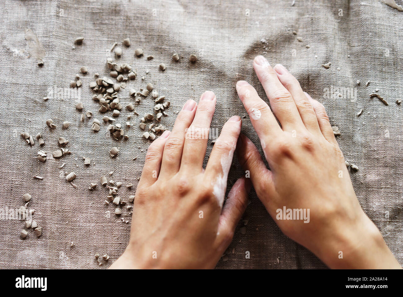 Mani femminili in una creta bagnata. Atelier di ceramica. Tessuto di lino. Foto Stock