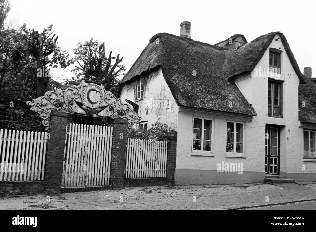 Malerisches altes Haus mit Hofeinfahrt in Wy auf der Insel Föhr, Deutschland 1960er Jahre. Scenic vecchia casa di corte con ingresso a Wyk su Foehr isola, Germania 1960s. Foto Stock Malerisches altes Haus mit Hofeinfahrt in Wy auf der Insel Föhr, Deutschland 1960er Jahre. Scenic vecchia casa di corte con ingresso a Wyk su Foehr isola, Germania 1960s. Foto Stock