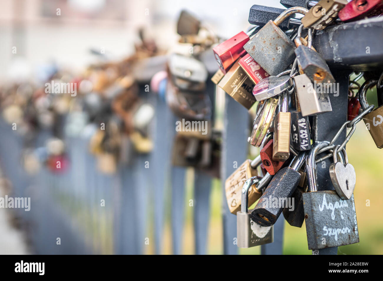 Un mazzetto di rusty amore lucchetti attaccato al ponte. Foto Stock
