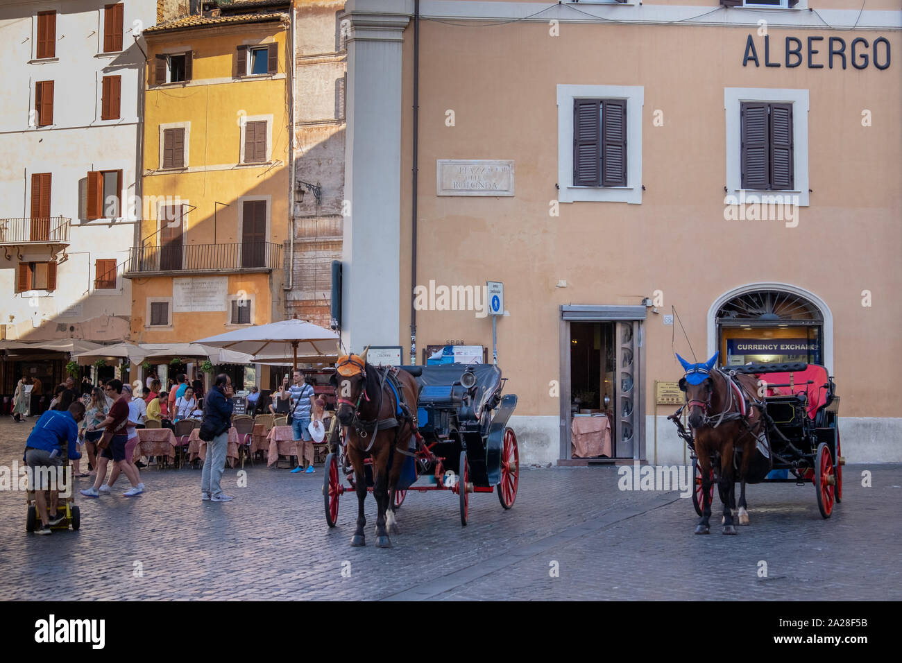 Due tradizionali turistica cavalli e carrozze sotto il sole in attesa della loro prossima tariffa, ogni protezione da indossare cappello da sole per il calore e la luce del sole. Foto Stock