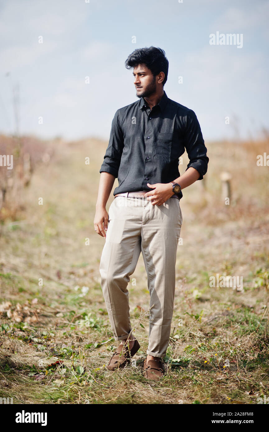 Indian Uomo in camicia nera e pantaloni beige poste nel campo Foto stock -  Alamy