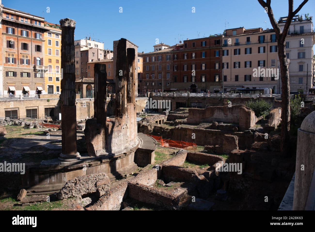 Resti della Roma antica catturato entro una moderna strada di circonvallazione e nuovi edifici - un enorme contratto antica troppo moderno. Ora utilizzato come un gatto santuario. Foto Stock