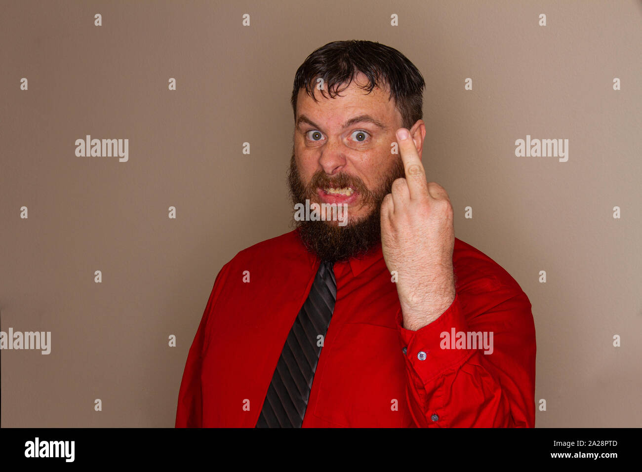 Uomo Barbuto facendo un gesto maleducato con il suo dito Foto Stock