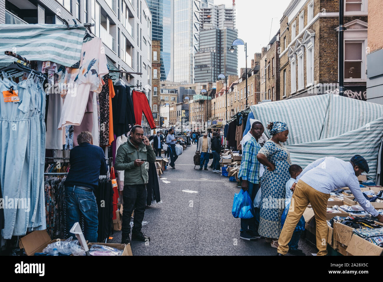 London, Regno Unito - 07 Settembre 2019: la gente a piedi e vestiti di esplorazione in vendita presso Pettycoat Lane market, un famoso moda e abbigliamento mercato nella EAS Foto Stock