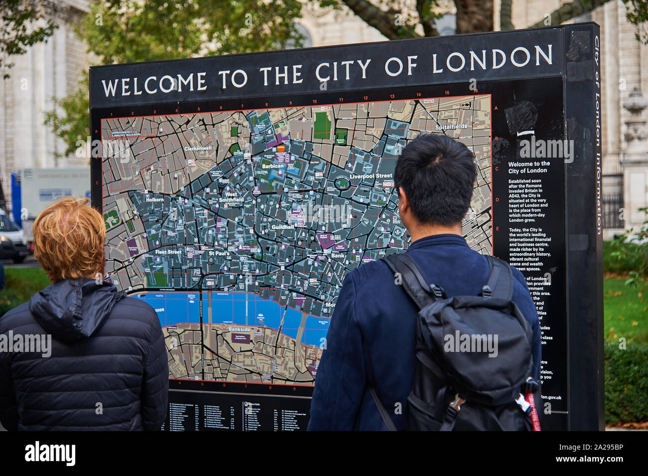 Due turisti maschio studiando una larga scala di mappa stradale della città di Londra Foto Stock