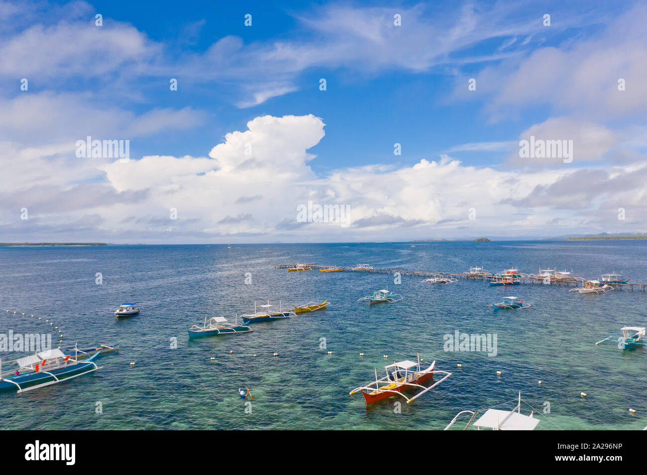 Paesaggio marino con barche e nuvole. Molte imbarcazioni turistiche nella baia durante il giorno. Siargao, Filippine, vista dall'alto. Foto Stock