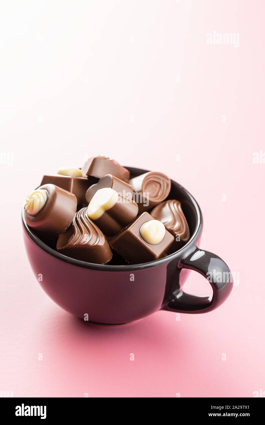 Dolci praline di cioccolato su sfondo rosa. Foto Stock