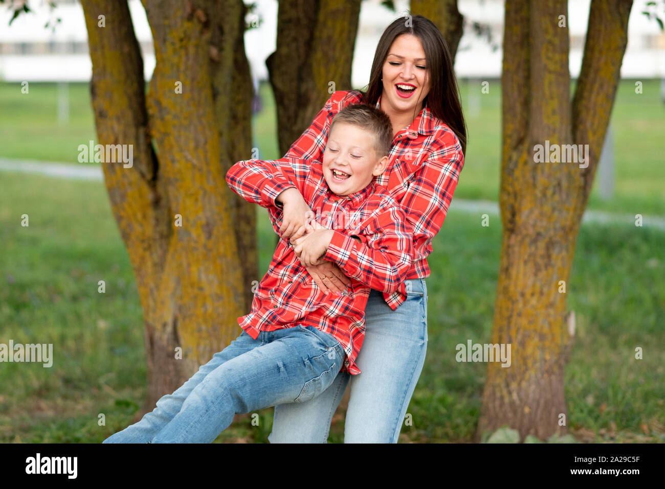 Mom, ridevano allegramente, volteggiare il suo figlio, tenendo tra le sue braccia. Foto Stock