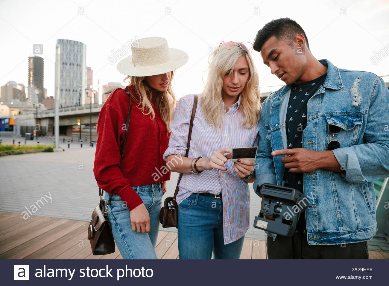 Giovani amici adulti guardando la fotografia istantanea Foto Stock