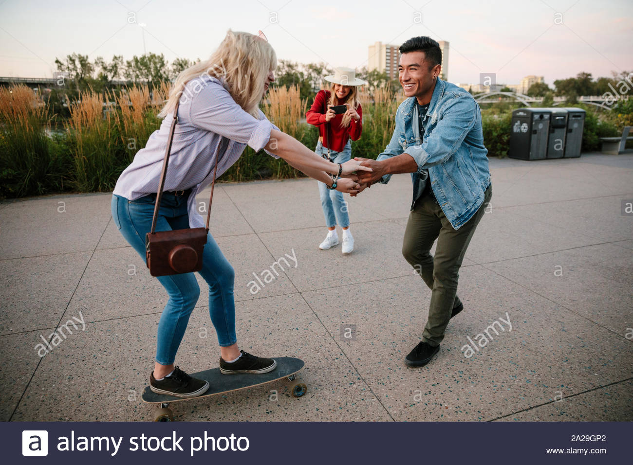 Giocoso coppia giovane riding skateboard Foto Stock