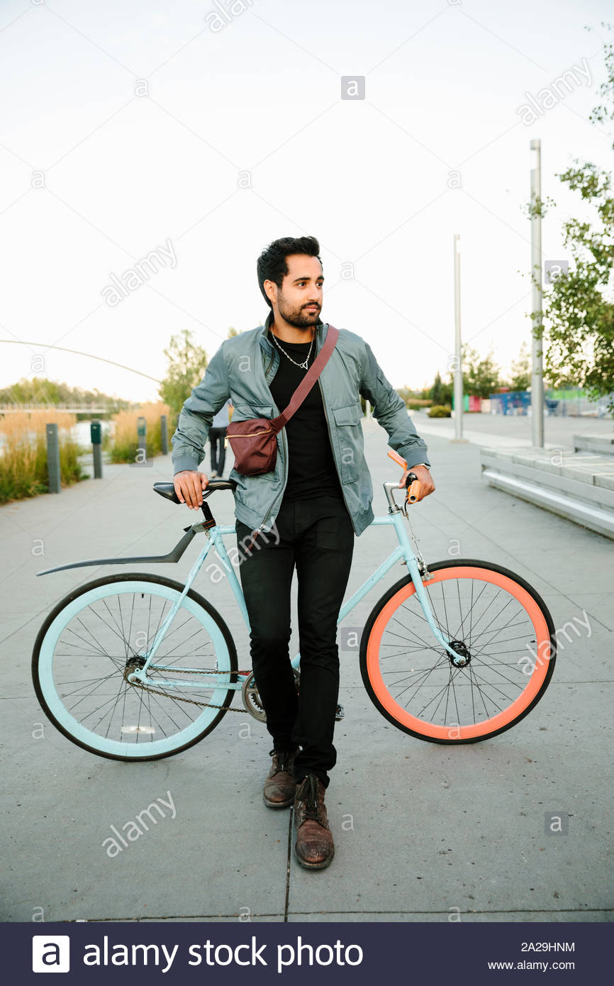 Ritratto fiduciosi, fresco giovane con noleggio biciclette Foto Stock