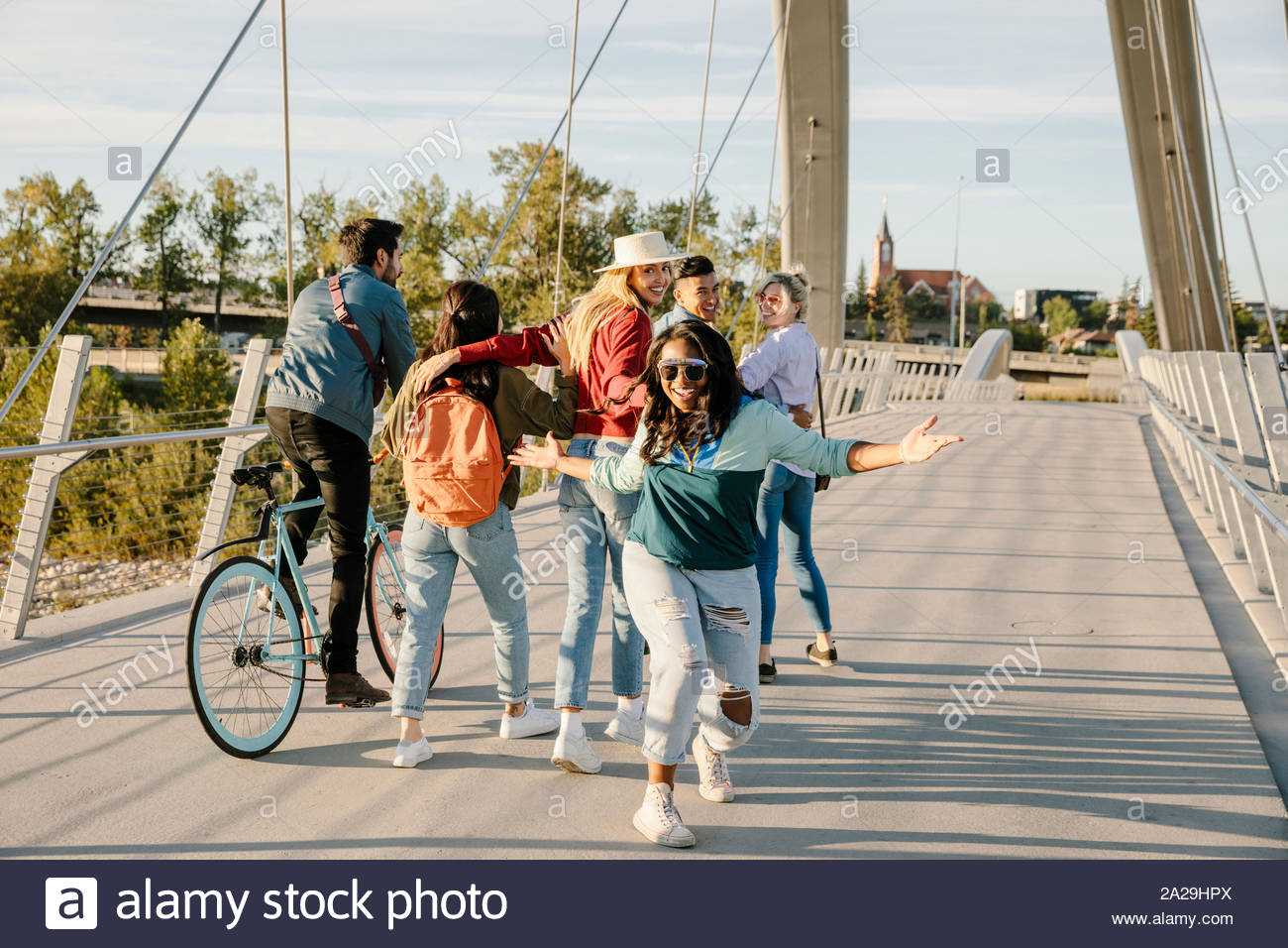 Giocoso Ritratto di giovane donna con gli amici sulla passerella di sole Foto Stock