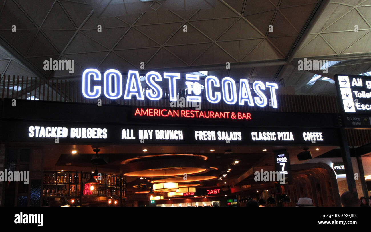 Da costa a costa di digital signage e logo che si vede presso il loro ristorante a Londra Stansted Airport. Foto Stock