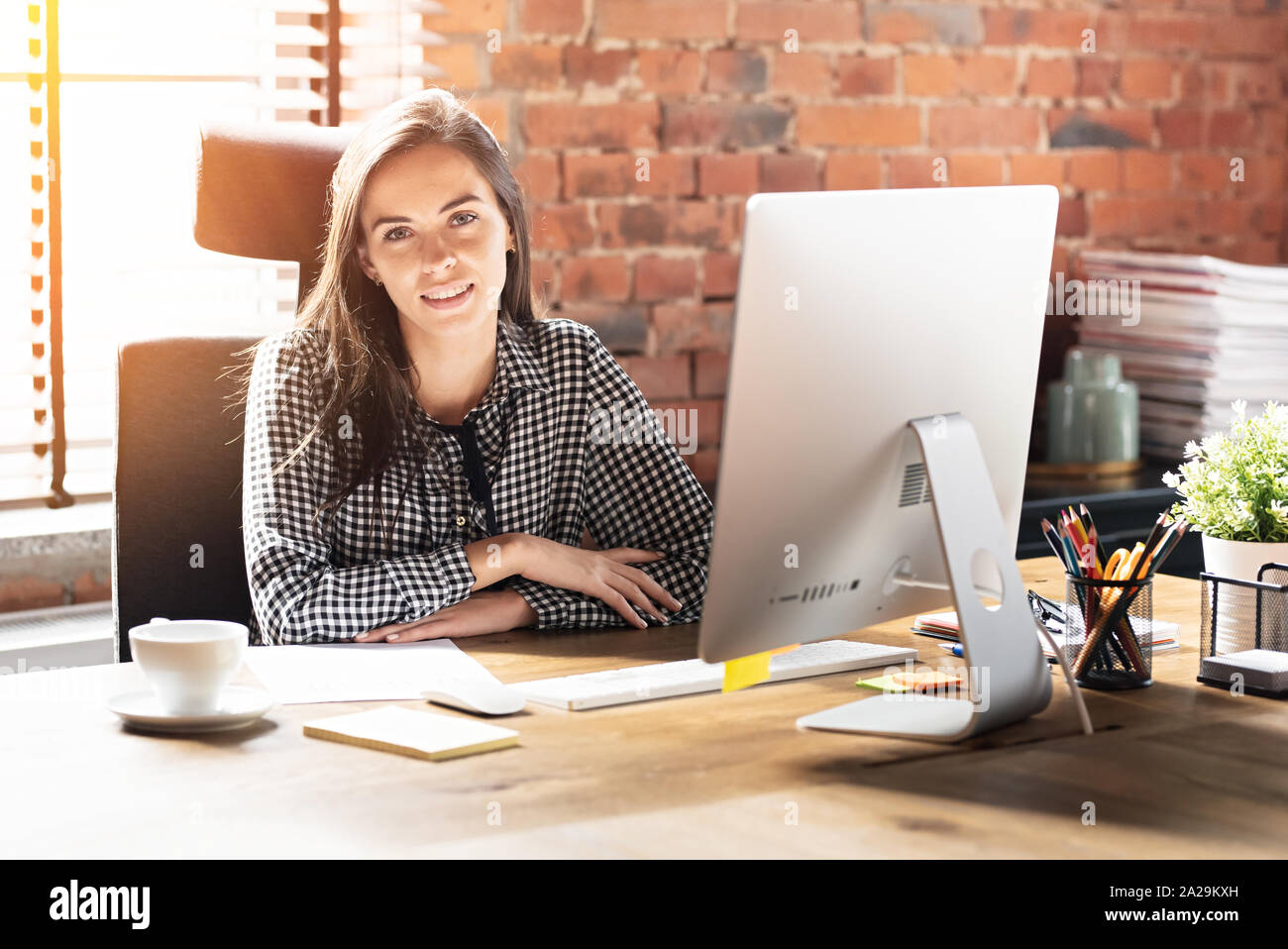 Donna che lavorano con il computer in ufficio. Sorridente giovane dipendente ritratto aziendale. Foto Stock