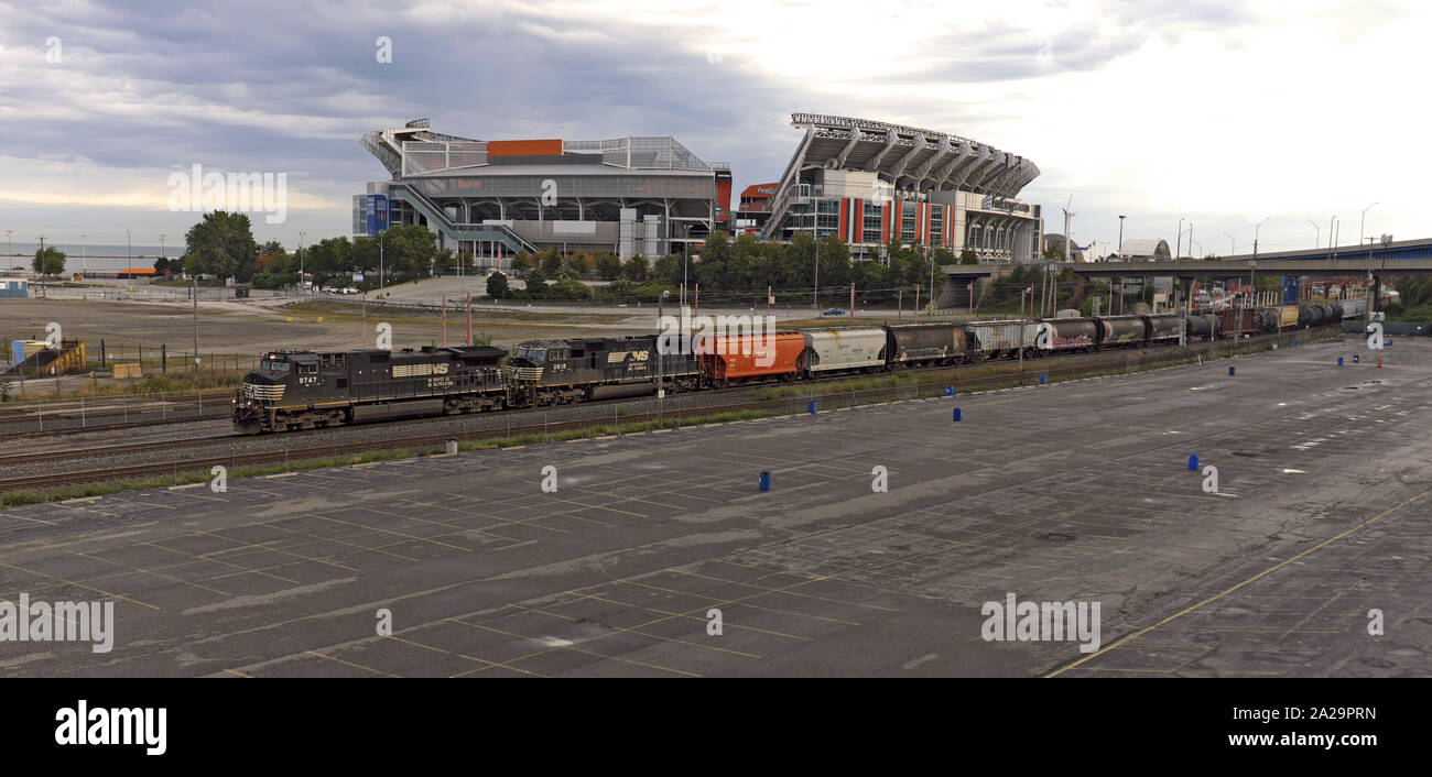 Un treno passa FirstEnergy Stadium, casa dei Cleveland Browns e il Lago Erie come si fa il suo modo a ovest attraverso il centro di Cleveland, Ohio, USA. Foto Stock