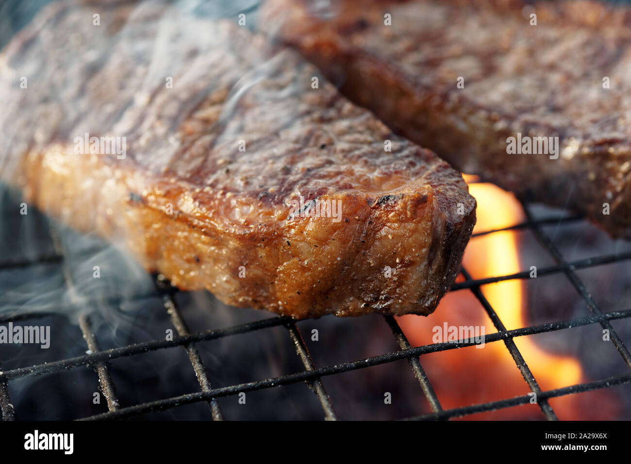 Due pezzi di bistecca di controfiletto su grill, picnic esterno Foto Stock
