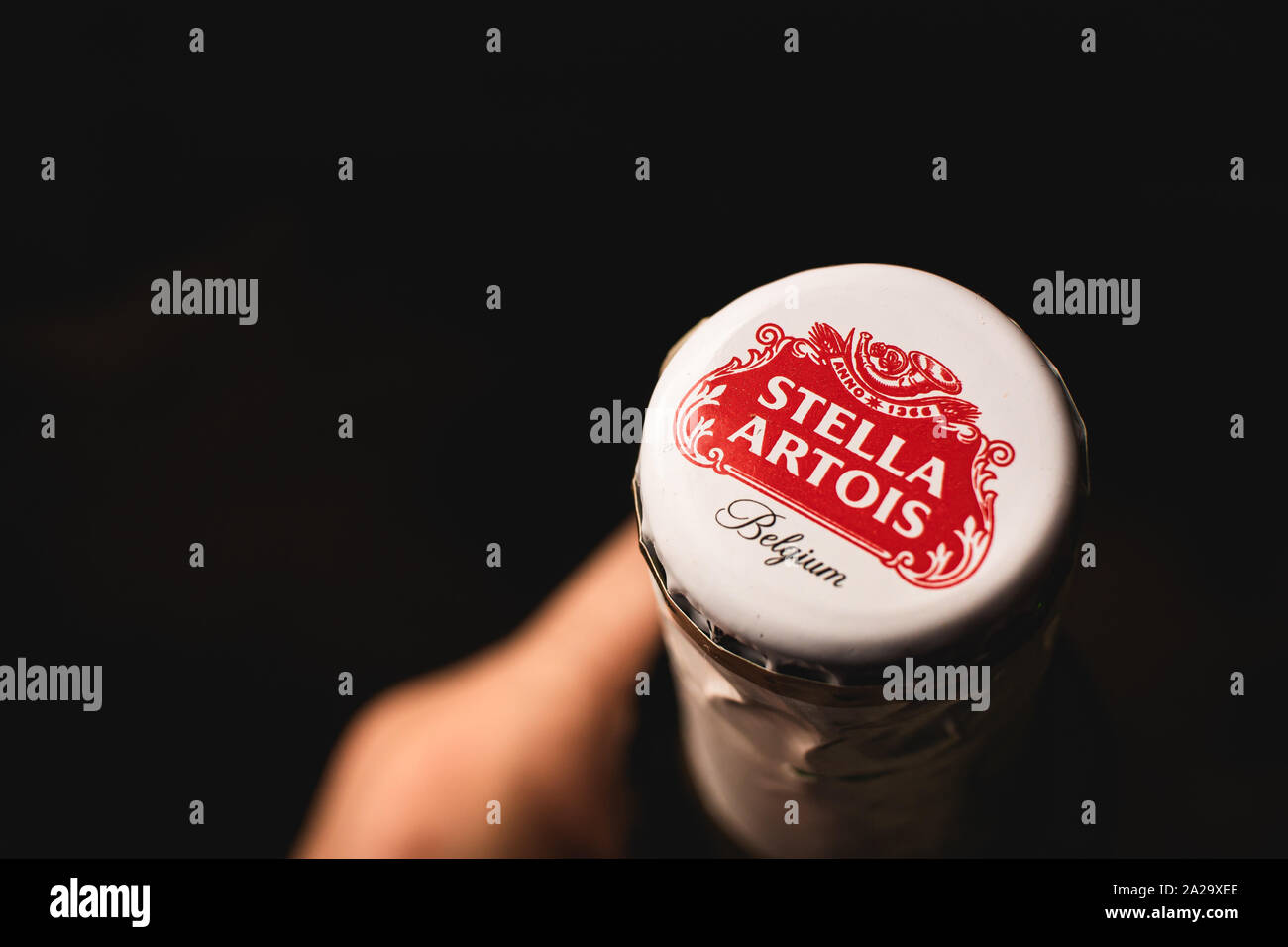 Fotografia di un uomo in possesso di una bottiglia di birra dalla società belga Stella Artois. Foto Stock