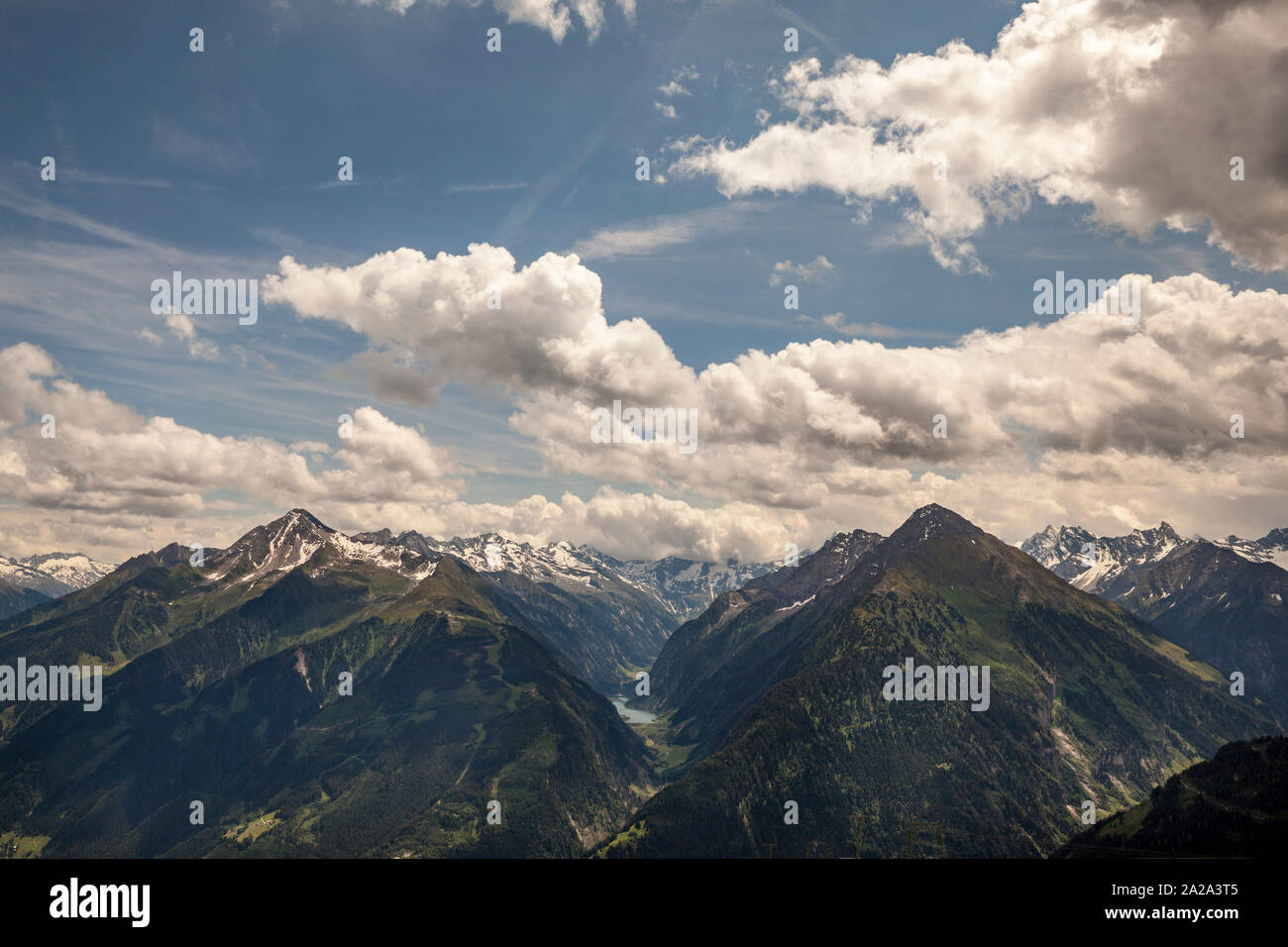 Vedute della snow-capped Penken Monti verso Stillup serbatoio con cielo blu e rotte aeree cloud, vicino Mayrhofen nelle Alpi austriache Foto Stock