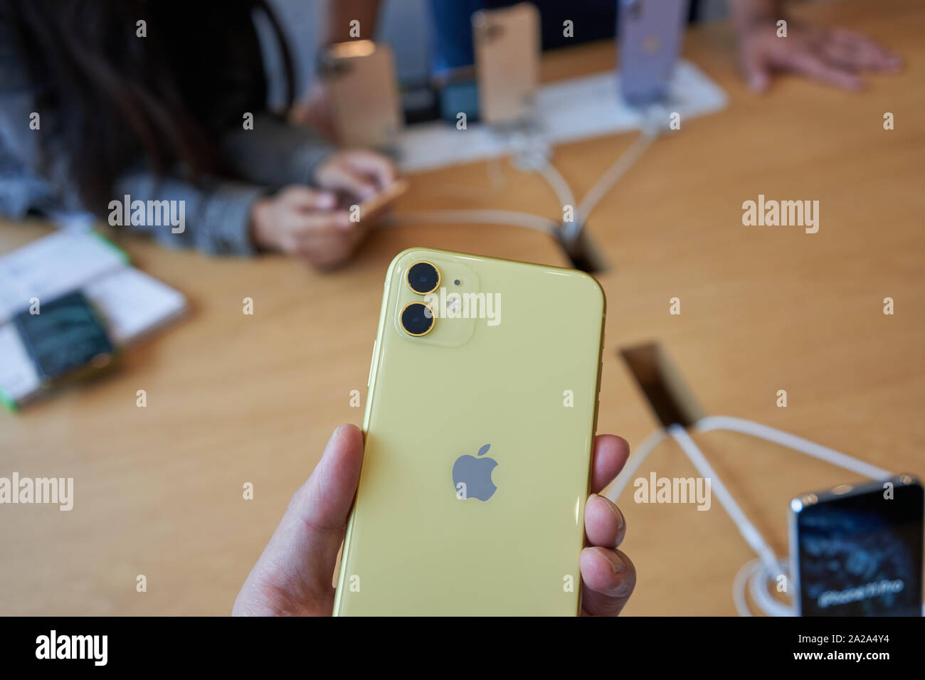 Portland, Oregon, Stati Uniti d'America - Sep 26, 2019: una shopper prende uno sguardo più da vicino al dual telecamere su un nuovo iPhone 11 in un Apple Store nel centro di Portland. Foto Stock
