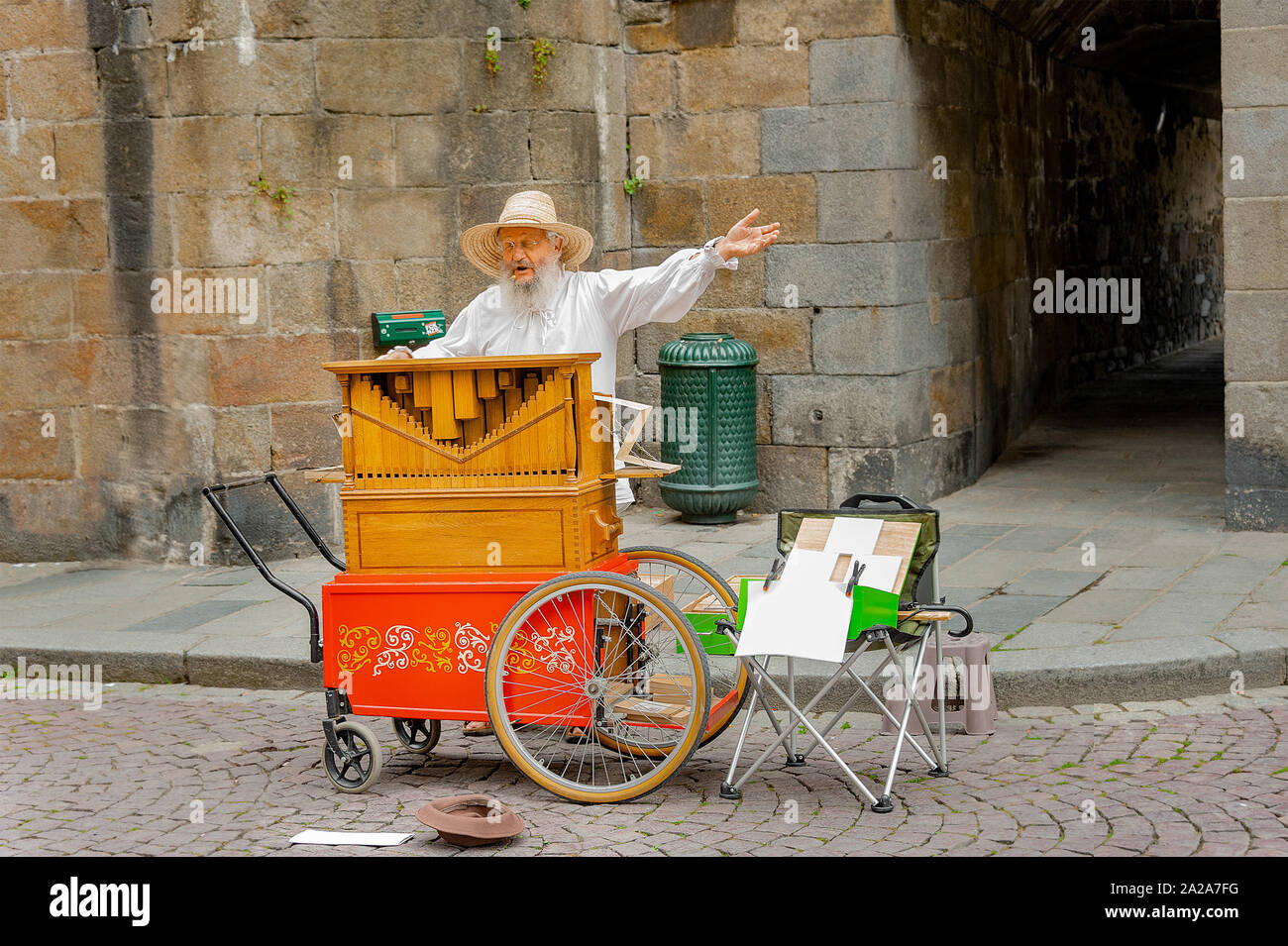 Saint Malo, Francia - Luglio 20, 2017: uomo vecchio con lungo il pane bianco sta dietro il suo organetto cantare durante la riproduzione il suo strumento musicale per suggerimenti. Foto Stock