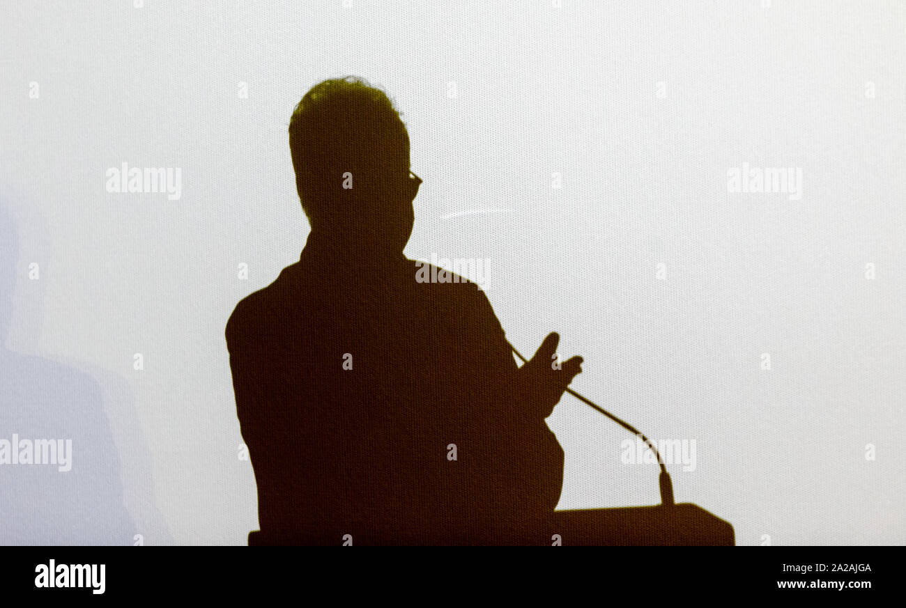 Amburgo, Germania. 01 ott 2019. L'ombra di Albert Wiederspiel, direttore della Hamburg Film Festival, cade su uno schermo durante il suo intervento al Douglas-Sirk cerimonia del premio per l'attrice Nina Hoss. Credito: Markus Scholz/dpa/Alamy Live News Foto Stock