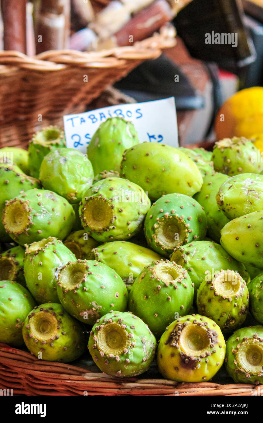 Verde di frutti di Opuntia su un mercato locale a Funchal, Madeira, Portogallo. Ficodindia o di fichi d'India. Frutti Esotici sono cresciute su cactus. Traduzione del segno: Tabaibos - Frutti di Opuntia in portoghese. Foto Stock