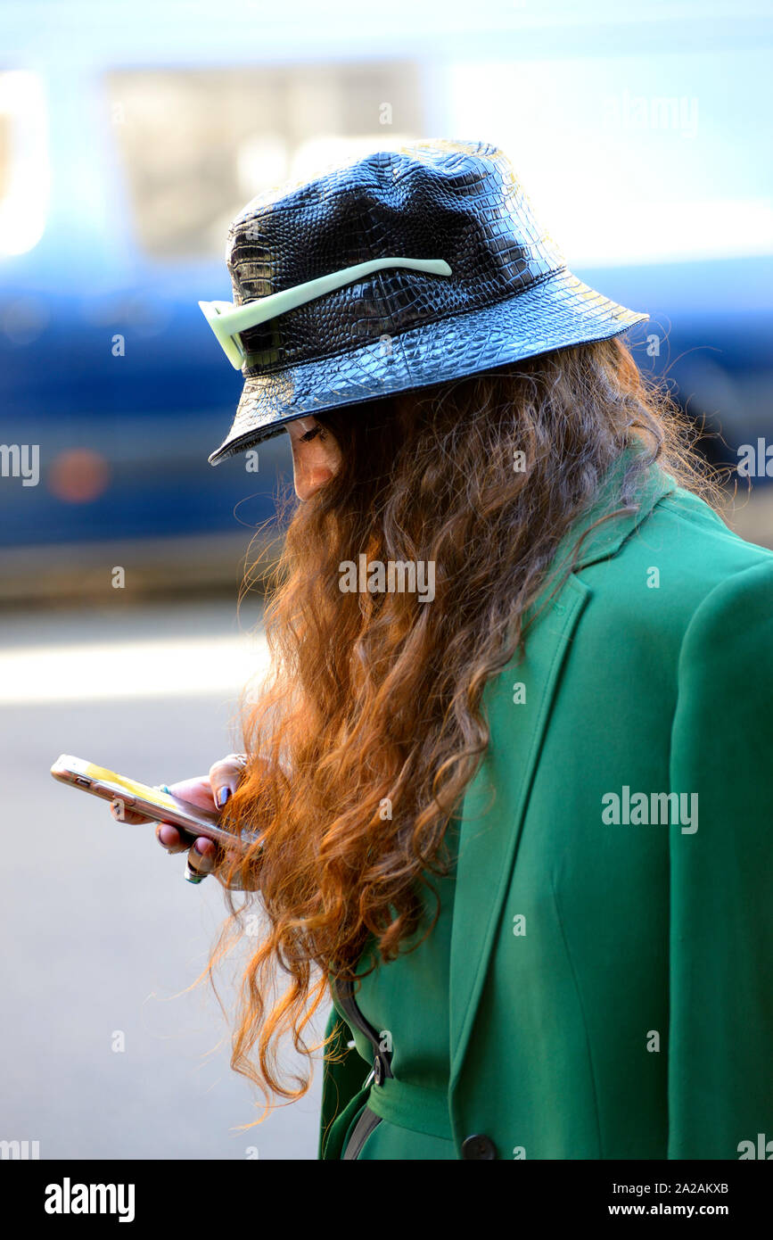 Modello sul suo telefono cellulare presso la London Fashion Week, 2019. Foto Stock