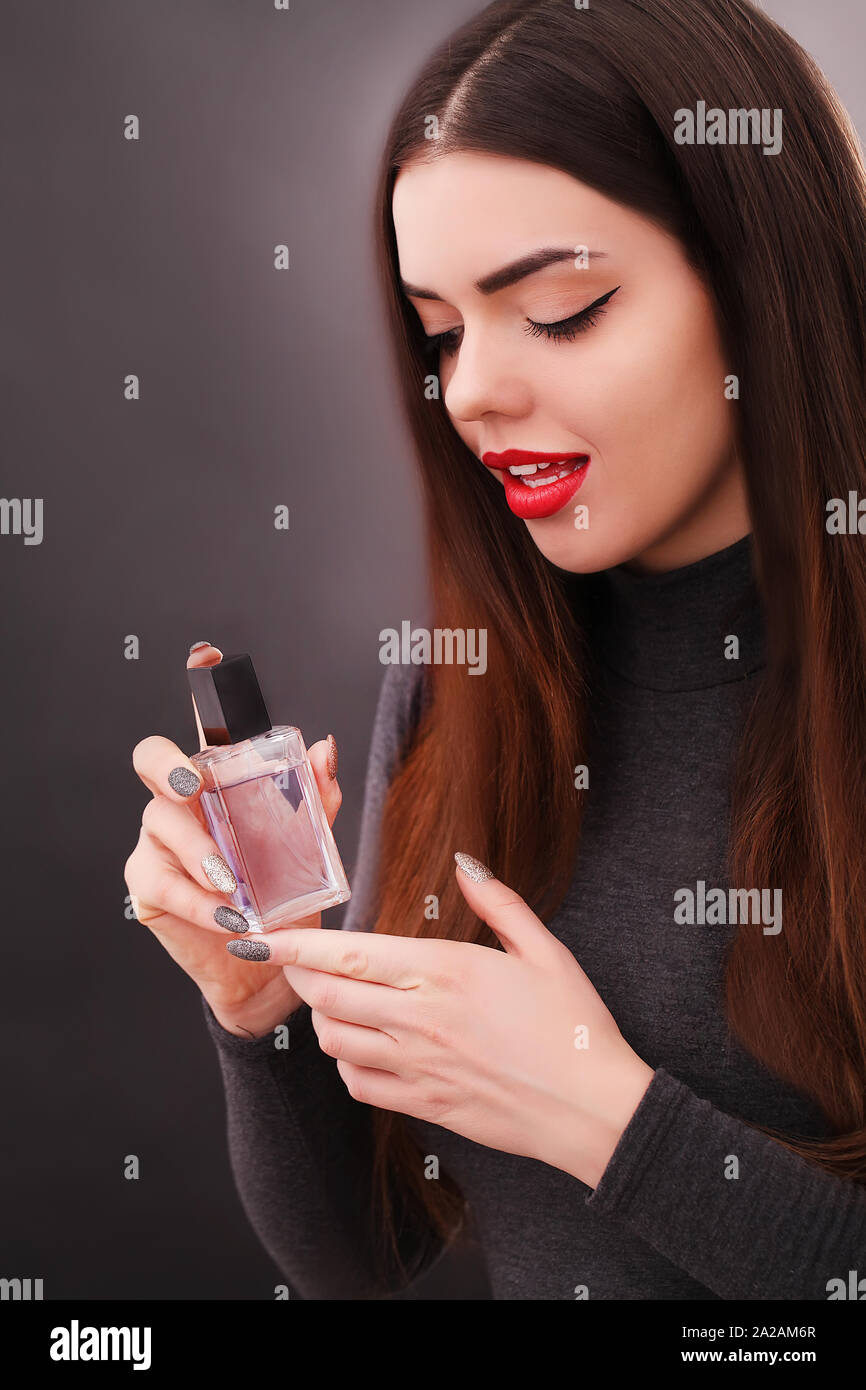 Giovane donna sorridente spraing parfumes in bagno Foto Stock
