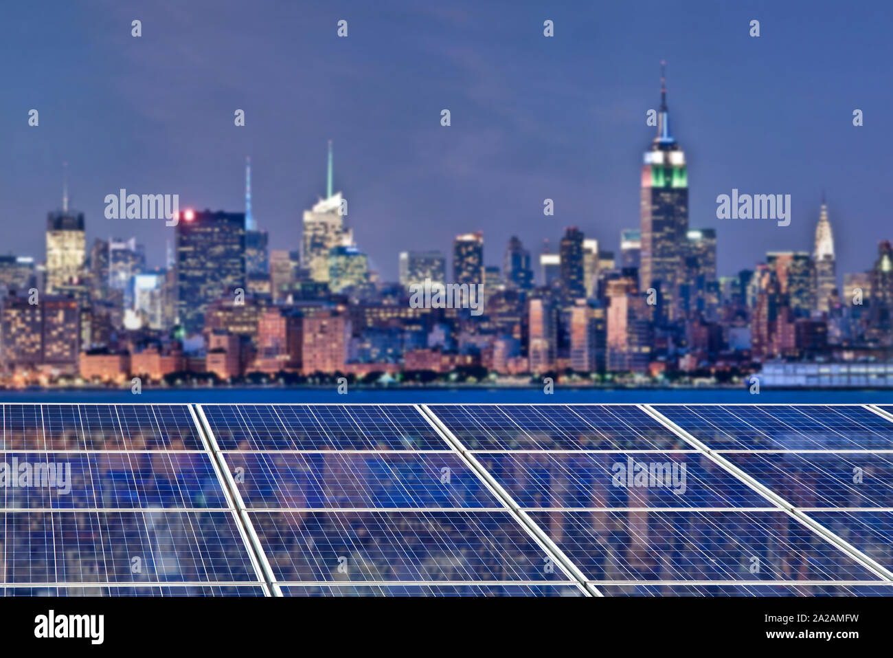 Blue pannelli a celle solari, skyline di New York illuminata di notte in background Foto Stock