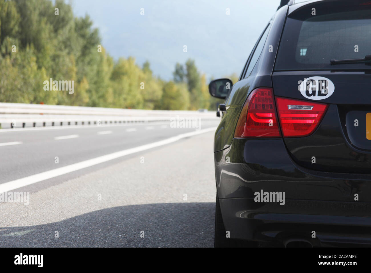 Una foto di un'auto parcheggiata sul lato della strada, con il logo GB chiaramente in mostra. Bella profondità di limatura della strada in lontananza. Foto Stock